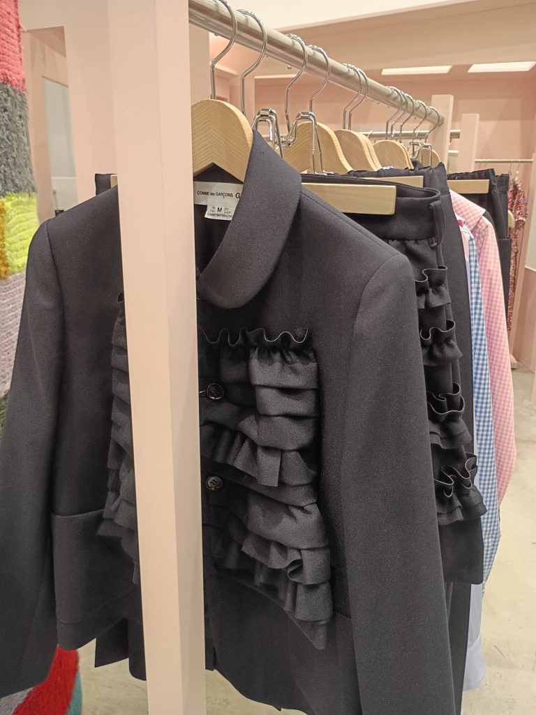 Contemporary designer clothing displayed on a curated retail rack inside Dover Street Market New York